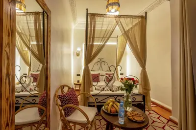 a room with a table and chairs and a mirror at Riad des remparts Marrakech in Marrakech