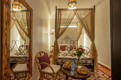 a room with a table and chairs and a mirror at Riad des remparts Marrakech in Marrakech