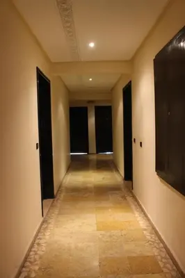 an empty hallway with black doors and a television at Studio Salmiya Dune in Marrakech