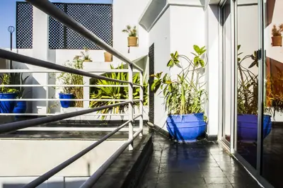 a balcony with potted plants in blue pots at Riad THALGE in Marrakech