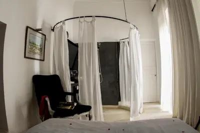 a bedroom with a bed and a chair and a window at Riad THALGE in Marrakech