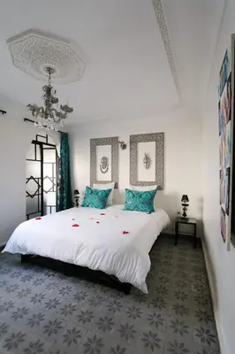 a bedroom with a large white bed with blue pillows at La Voûte Étoilée in Marrakech