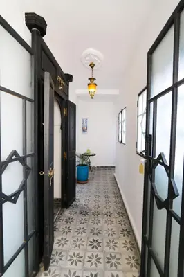 a hallway with black doors and a tile floor at La Voûte Étoilée in Marrakech