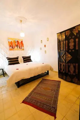 a bedroom with a bed and a rug on the floor at La Voûte Étoilée in Marrakech