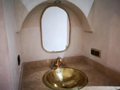 a bathroom with a gold sink with a window at Riad azra Marrakech in Marrakech