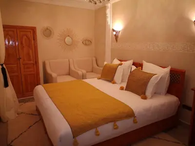 a bedroom with a large bed with a yellow blanket at Riad azra Marrakech in Marrakech
