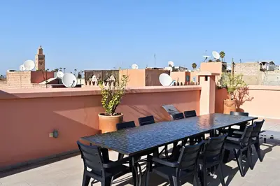 a black table and chairs on the roof of a building at Riad Dar DARRE in Marrakech