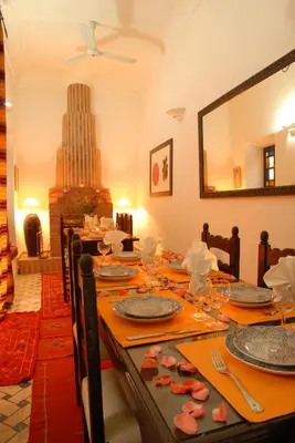 a dining room with a table with plates and glasses at Riad Al Jana in Marrakech