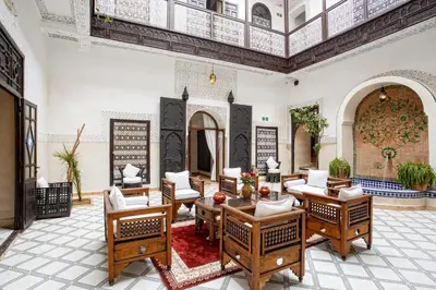 a living room with wooden furniture and a ceiling at Riad Al Jana in Marrakech