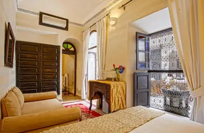 a living room with a bed and a fireplace at Riad Al Jana in Marrakech