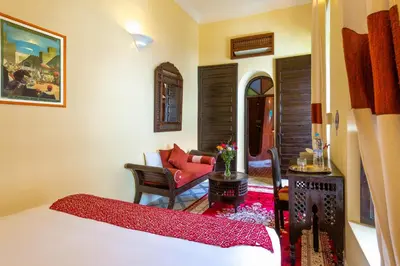 a bedroom with a bed and a living room at Riad Al Jana in Marrakech