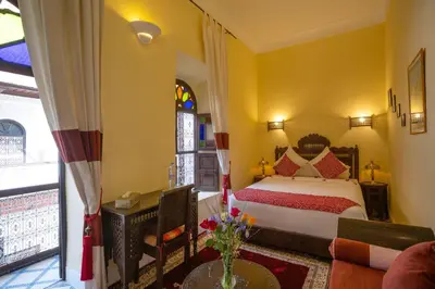 a bedroom with a bed and a living room at Riad Al Jana in Marrakech