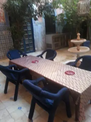a patio with two tables and chairs and a fountain at RIAD DAR KADER chambre saumon in Marrakech
