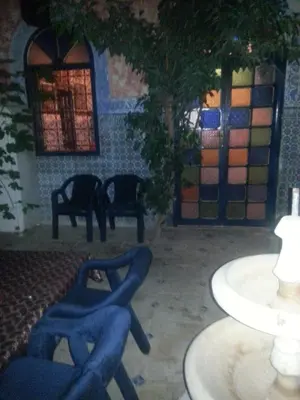 a patio with chairs and a table and a tree at RIAD DAR KADER chambre saumon in Marrakech