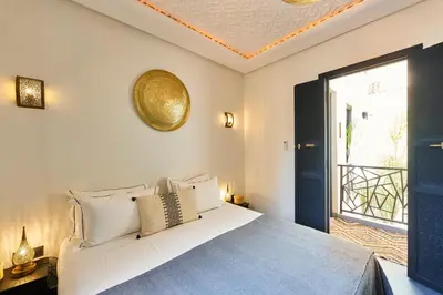a bedroom with a bed and a large window at Riad Miloud en exclusivité 10 P au cœur de la Médina in Marrakech