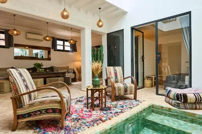 a living room with a swimming pool and chairs at Riad Miloud en exclusivité 10 P au cœur de la Médina in Marrakech