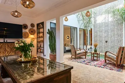 a living room with a glass table and chairs at Riad Miloud en exclusivité 10 P au cœur de la Médina in Marrakech
