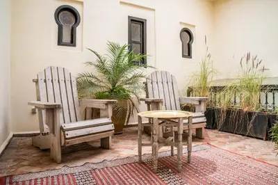 two wooden chairs and a table on a patio at Riad Adilah Marrakech - by EMERALD STAY in Marrakech