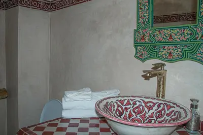 a bathroom with a sink and a table with towels at Riad Dar Tamlil in Marrakech