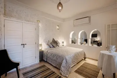 a bedroom with a bed and a table and two mirrors at Riad Spice by Marrakech Riad in Marrakech