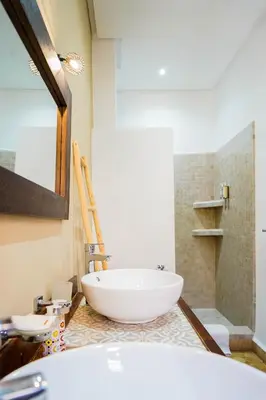 a bathroom with a large white tub and a shower at Riad NayaNour in Marrakech