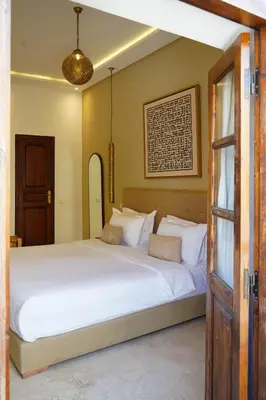 a bedroom with a large bed with white sheets at Riad NayaNour in Marrakech