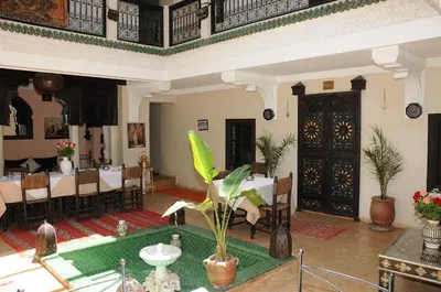 a large room with a table and chairs and a room with a table at Riad Haraka in Marrakech
