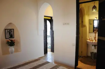 a hallway with an archway and a door to a room at Riad Haraka in Marrakech