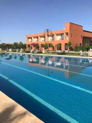 a large swimming pool in front of a building at Palais Benfatah in Marrakech
