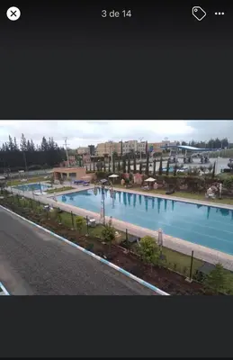 a view of a large swimming pool with buildings in the background at Palais Benfatah in Marrakech