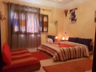 a bedroom with two beds and a couch at Zaitouna, Quiet apartment, Modern in Marrakech