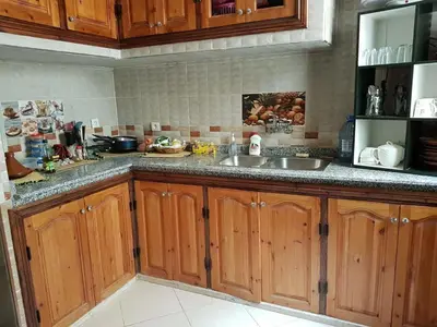a kitchen with wooden cabinets and a sink at Zaitouna, Quiet apartment, Modern in Marrakech