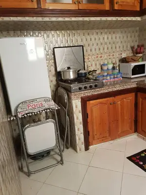 a kitchen with a chair next to a stove at Zwina Appart, A Small, Cozy Family Nest in Marrakech