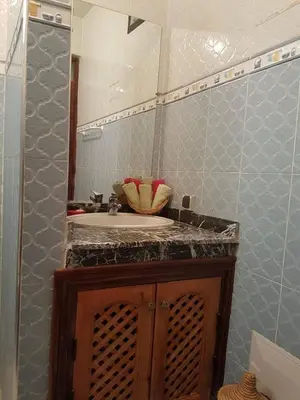 a bathroom with a sink and a mirror at Zwina Appart, A Small, Cozy Family Nest in Marrakech