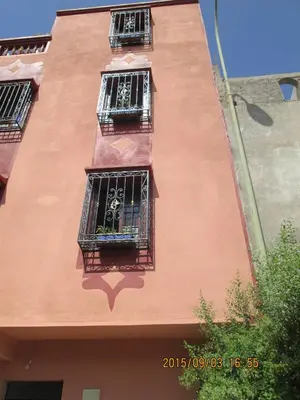 a building with three windows with plants in them at Zwina Appart, A Small, Cozy Family Nest in Marrakech
