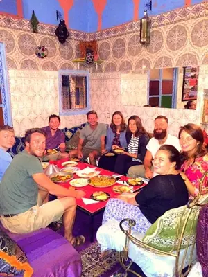 a group of people sitting around a table eating at Hostel Marrakech Rouge in Marrakech
