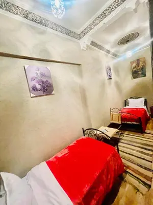 a bedroom with two beds with red and white sheets at Hostel Marrakech Rouge in Marrakech