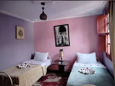two beds in a room with pink walls at Hostel Marrakech Rouge in Marrakech