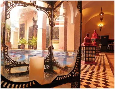 a candle on a glass table in a room with a pool at Riad La Rose D'orient in Marrakech