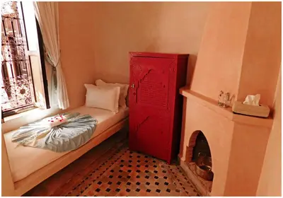 a small bedroom with a red cabinet next to a window at Riad La Rose D'orient in Marrakech