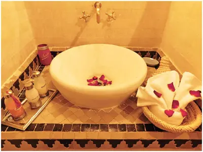 a bathroom with a white bowl with flowers in it at Riad La Rose D'orient in Marrakech