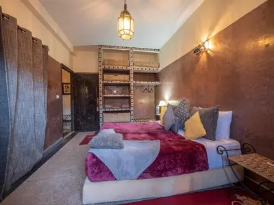 a bedroom with a large bed with a red blanket at Villa Soraya Hammam & Jacuzzi in Marrakech