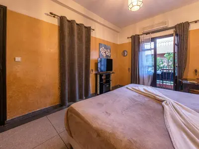 a bedroom with a bed and a tv and a window at Villa Soraya Hammam & Jacuzzi in Marrakech