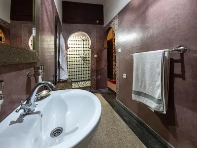 a bathroom with a white sink and a mirror at Villa Soraya Hammam & Jacuzzi in Marrakech