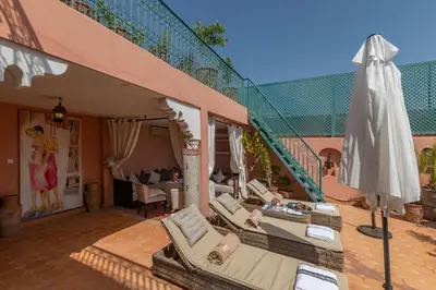 a patio with a umbrella and chairs and a table at Villa Soraya Hammam & Jacuzzi in Marrakech