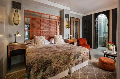 a bedroom with a bed and a desk and a chair at Riad 72 in Marrakech