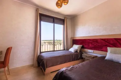 a bedroom with two beds and a window at VILLA Waky & Golf - Jardin de l'Atlas in Marrakech