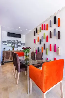 a dining room with orange chairs and a glass table at VILLA Waky & Golf - Jardin de l'Atlas in Marrakech