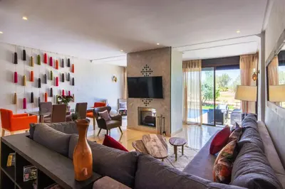 a living room with a couch and a tv at VILLA Waky & Golf - Jardin de l'Atlas in Marrakech