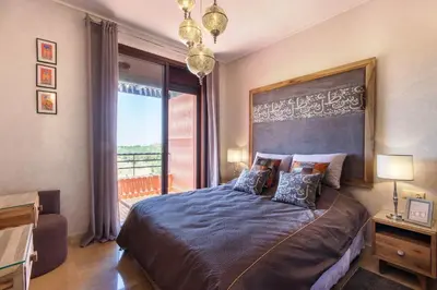 a bedroom with a large bed with a large window at VILLA Waky & Golf - Jardin de l'Atlas in Marrakech